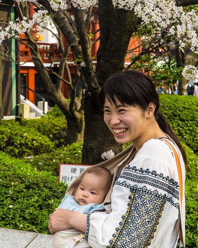 微笑的女人带着孩子在白天
